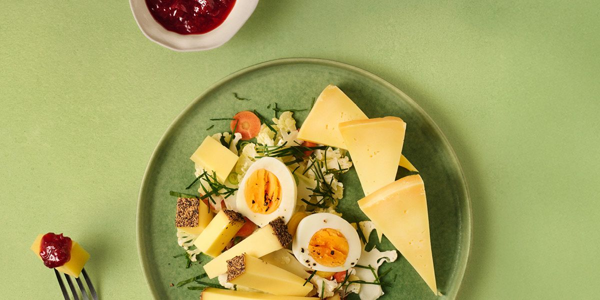 Erdbeer-Chutney mit Käse und gekochten Eiern auf grünem Teller angerichtet