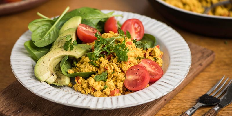 Angerichtetes Rührtofu mit Avocado und Tomaten
