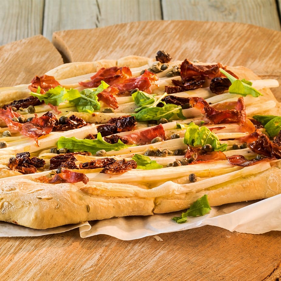 Spargel-Focaccia mit getrockneten Tomaten, Schinken und Rucola
