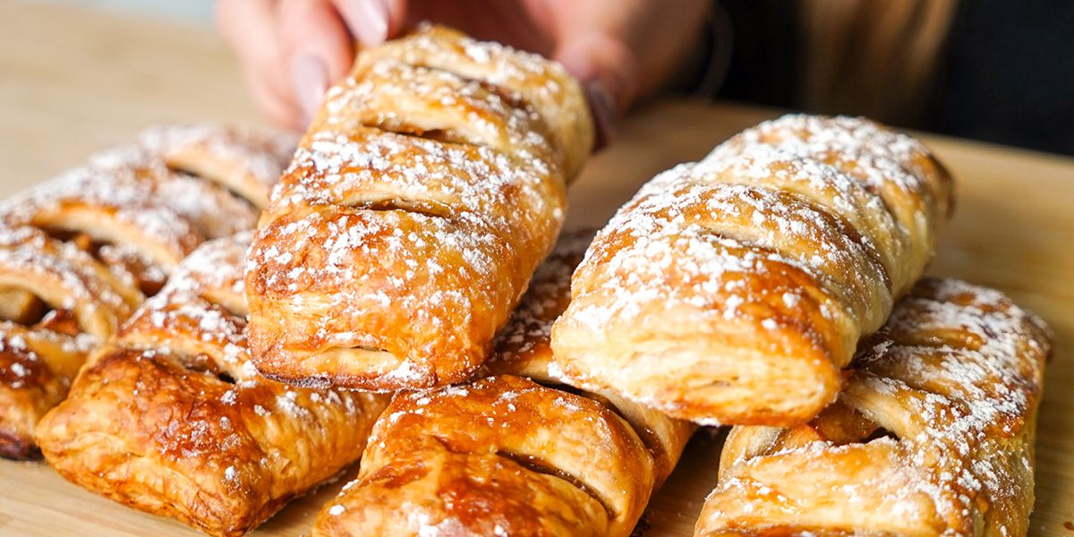 Mehrere mit Puderzucker bestreute Apfeltaschen aufeinander gestapelt.