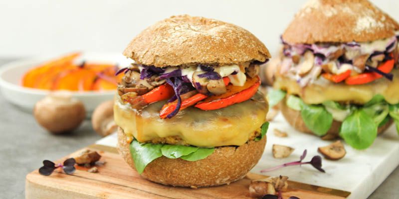 Zwei Veggieburger belegt mit Rotkohl, Kürbis, Champignons und Tofupatty.